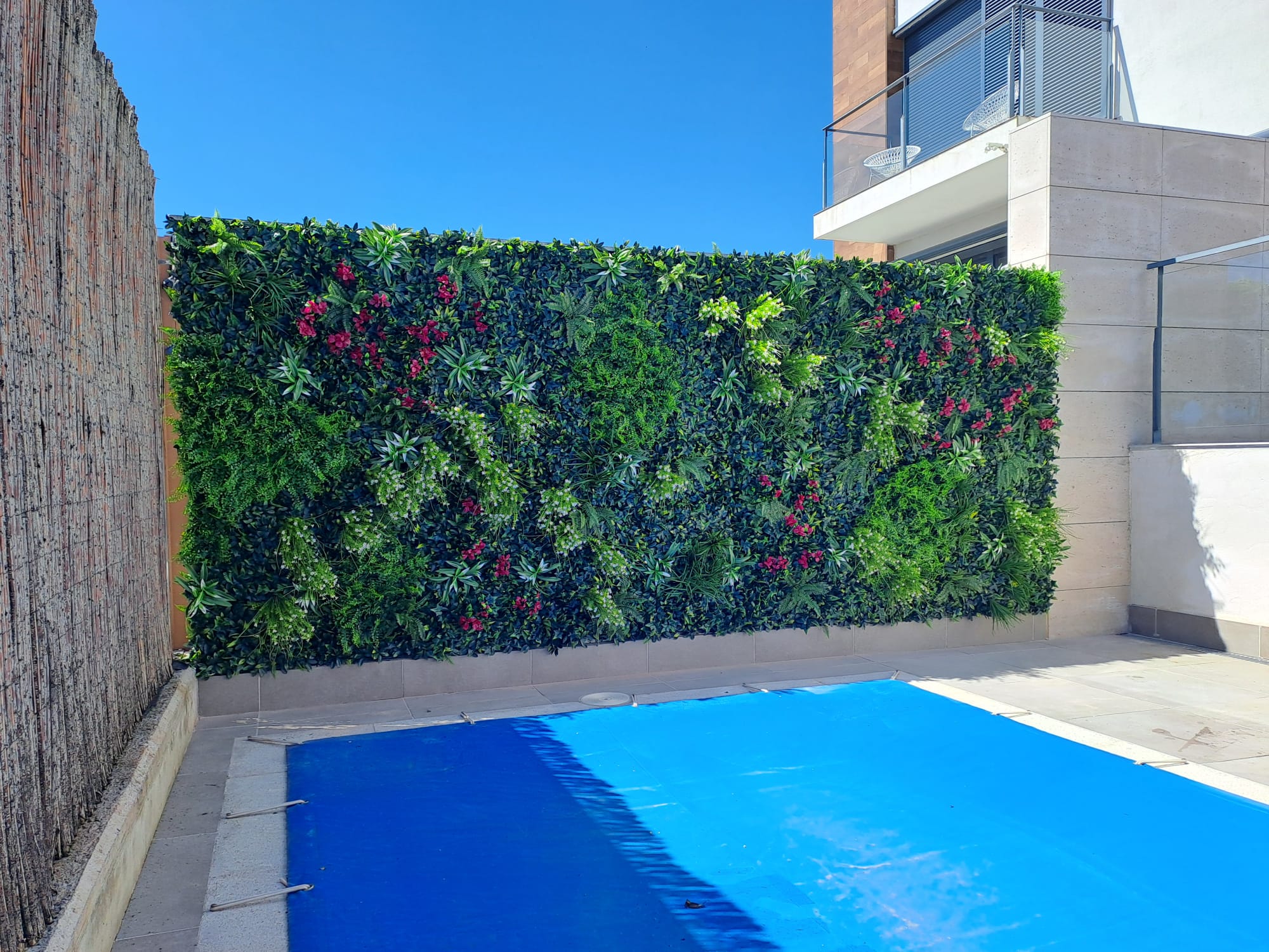 Patio vegetal en vivienda premium con vegetación a medida y cierre visual elegante