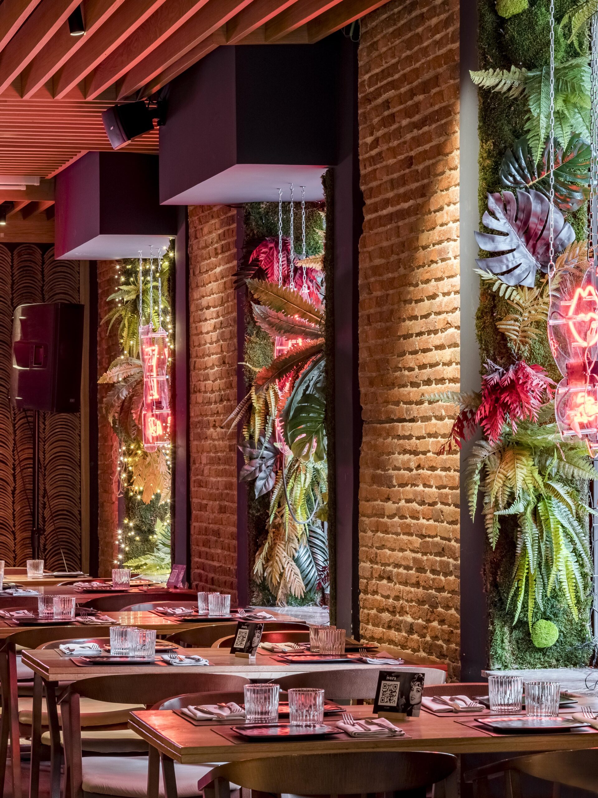 Jardín vertical integrado en el interior de un restaurante premium junto a mesas y ventanales