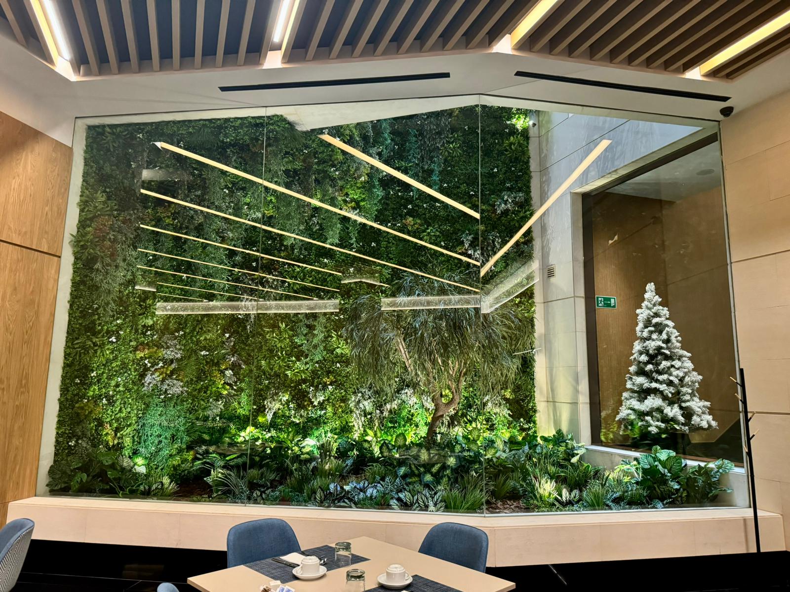 Composición vegetal a medida en comedor de restaurante premium con iluminación arquitectónica